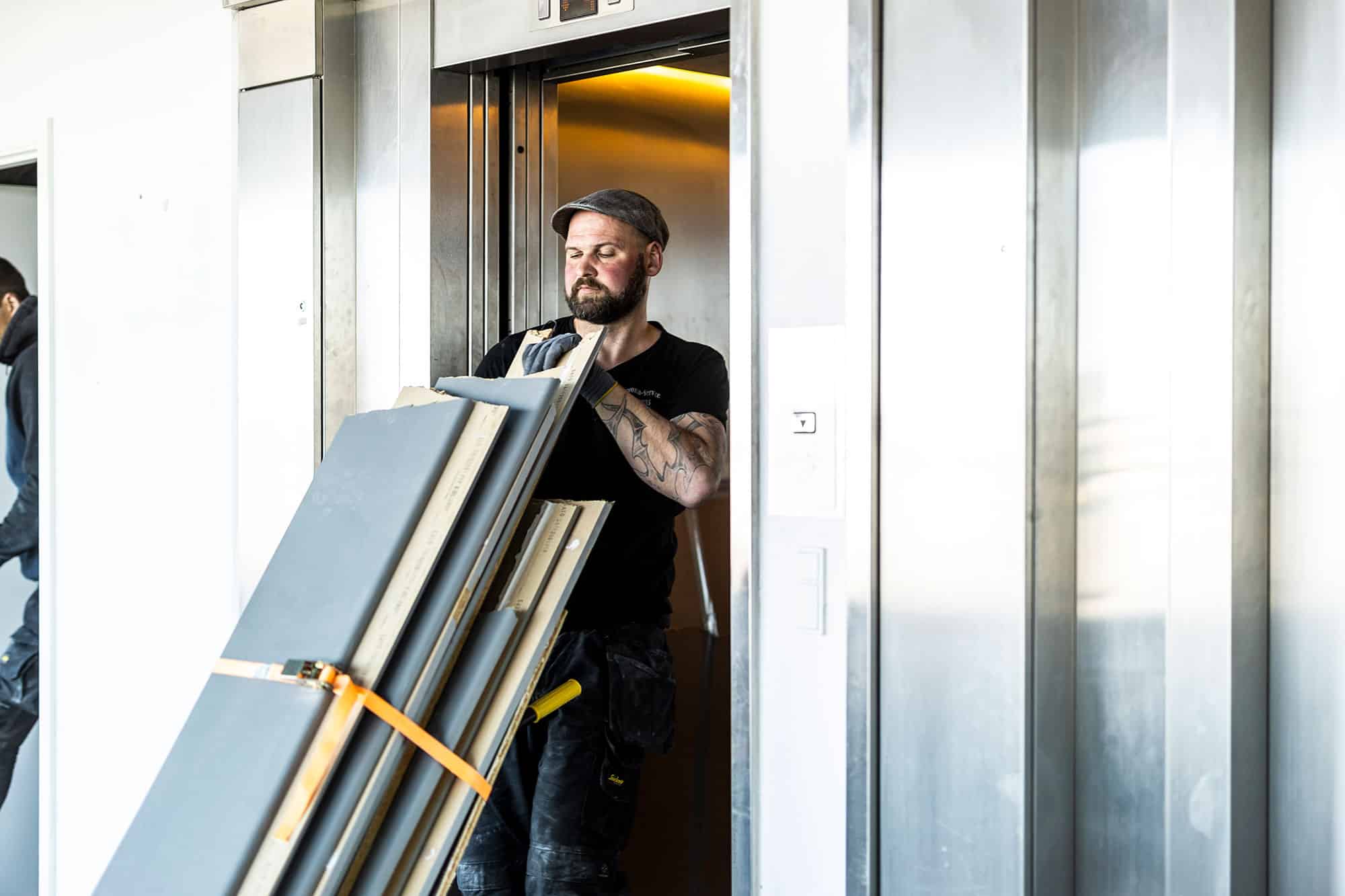 Medarbejder flytter materialer gennem en elevator